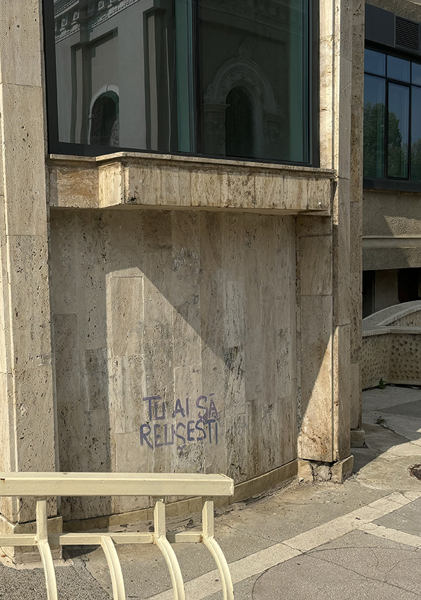A modernist building from the 1990s featuring graffiti that says "You will succeed," reflecting Banu Church, where I was baptized, in Iași, Romania