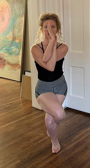 Ella Joseph practicing Eagle Pose, a yoga position with arms and legs crossed, balancing on one leg.